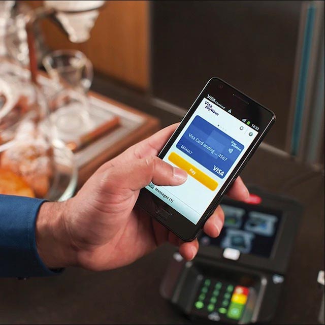 Person using Visa Paywave on a mobile phone.